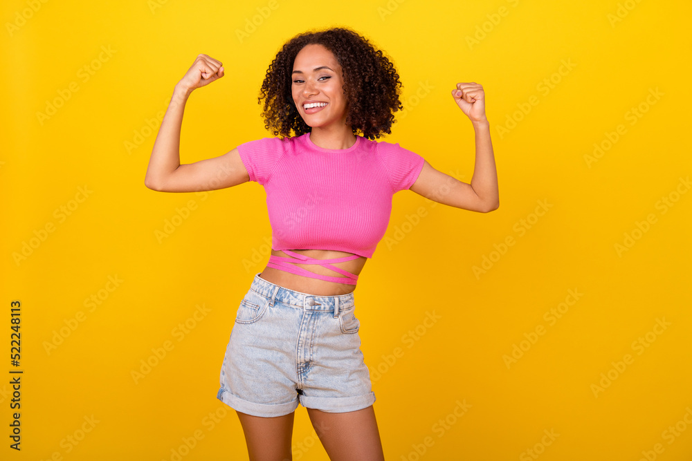 Portrait of cheerful nice person beaming smile arms show flex biceps isolated on yellow color background Portrait of cheerful nice person beaming smile arms show flex biceps isolated on yellow color background