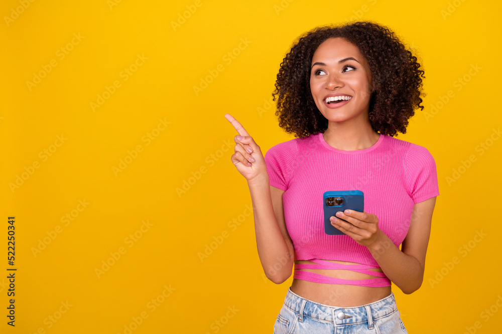 Photo of impressed brunette millennial lady hold telephone look up wear pink top isolated on bright orange color background Photo of impressed brunette millennial lady hold telephone look up wear pink top isolated on bright orange color background