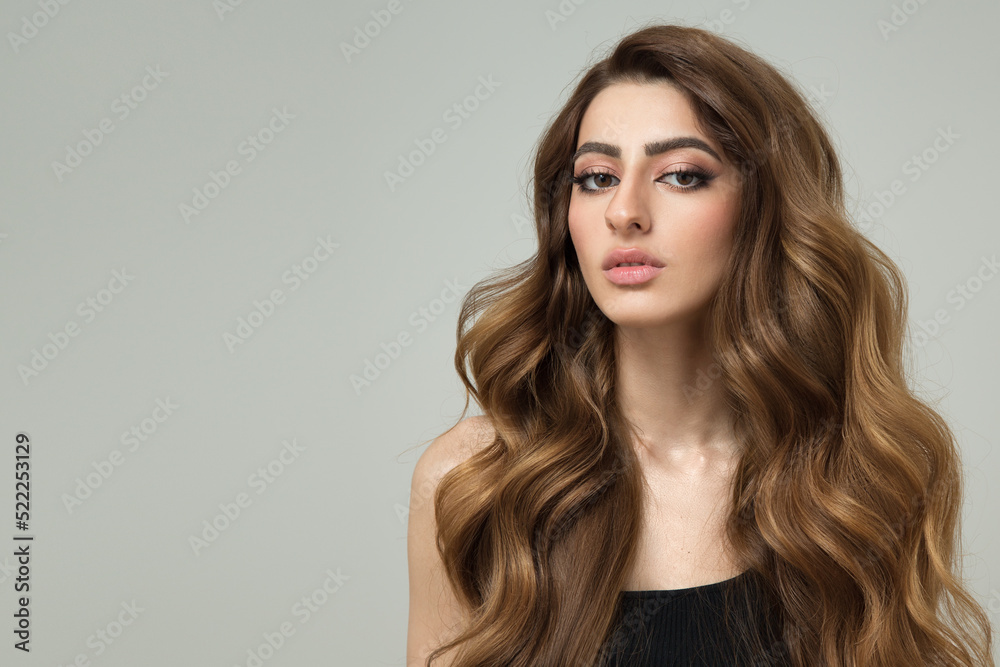 Naklejka premium Portrait of a beautiful brunette woman with long wavy hair. Copycpase