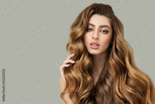 Portrait of a beautiful brunette with long wavy hair. Show off your curls. copyright