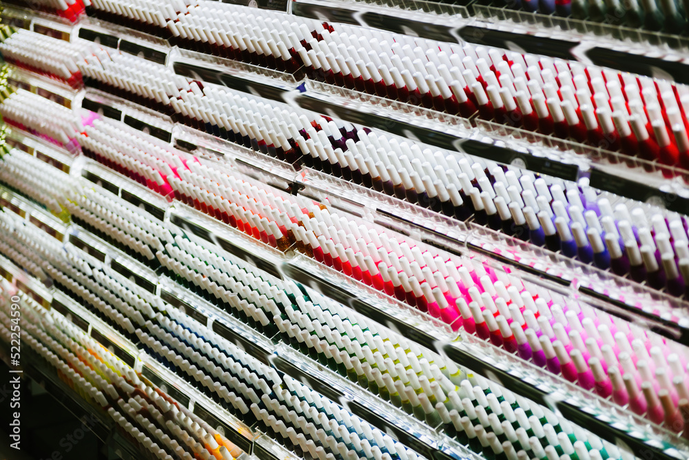 Row of multiple colorful rainbow selection of nail polish in cosmetics generic store