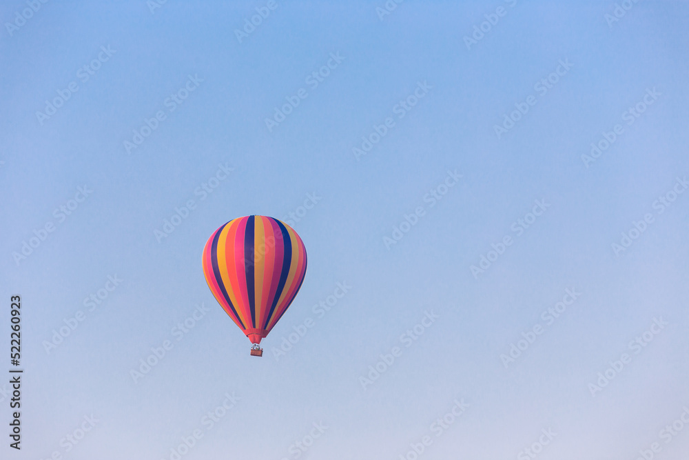 Colorful hot air balloon flying in the bright blue sky Colorful hot air balloon flying in the bright blue sky