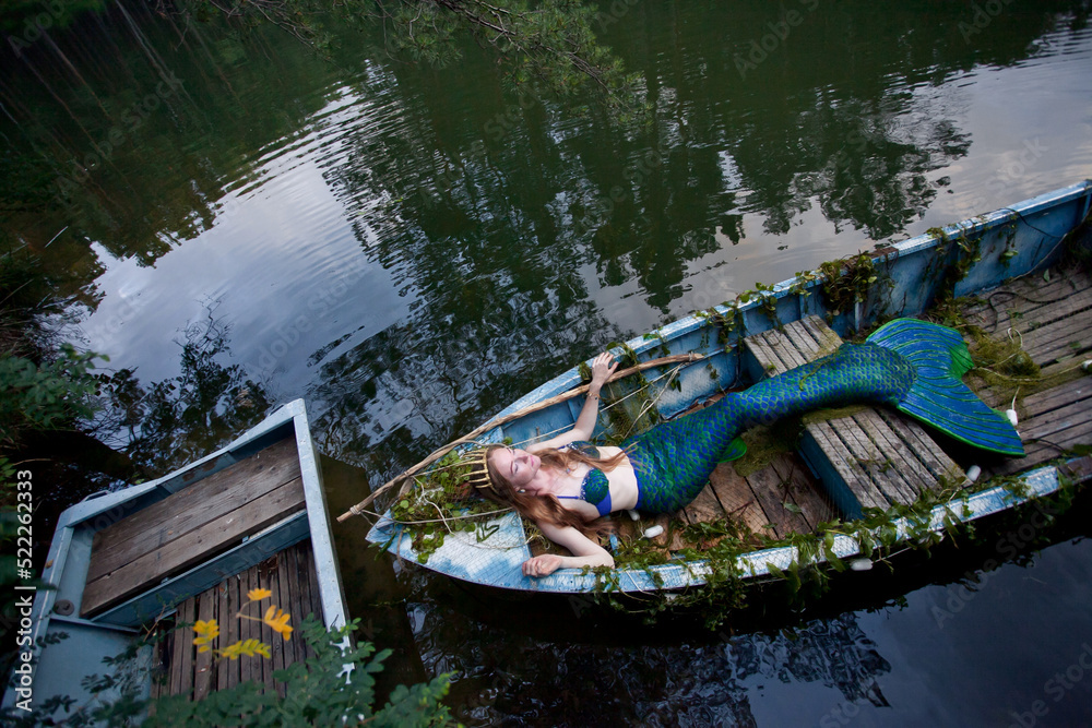 Mermaid story. The little mermaid sits in a boat. Mermaid at