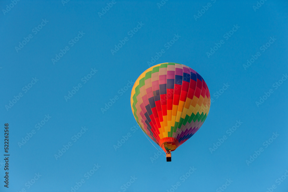 Obraz premium Colorful hot air balloon flying in the bright blue sky