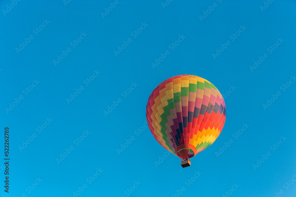 Obraz premium Colorful hot air balloon flying in the bright blue sky