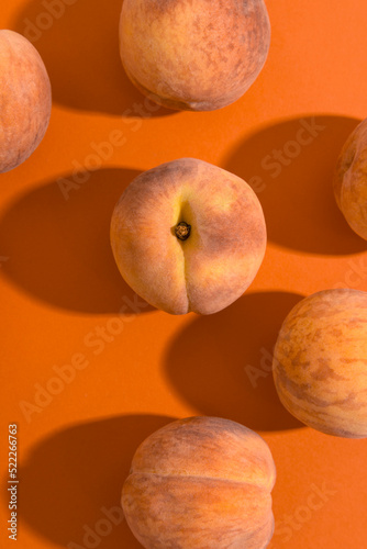 Peaches on a bright orange background, monochrome
