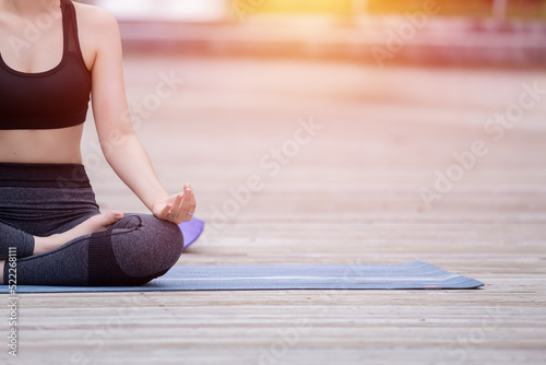 Closeup of hand woman sitting practices yoga lotus position outdoor. Meditation yoga concept.