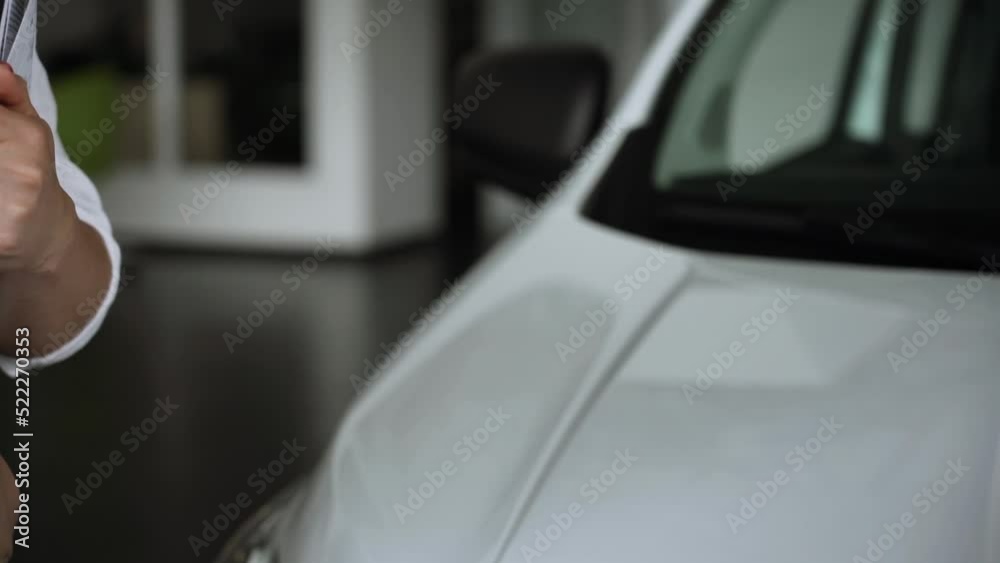 At automobile sales centre. Car salesperson selling new automobile to young family.Beautiful young couple at car showroom choosing a new car to buy At automobile sales centre. Car salesperson selling new automobile to young family.Beautiful young couple at car showroom choosing a new car to buy