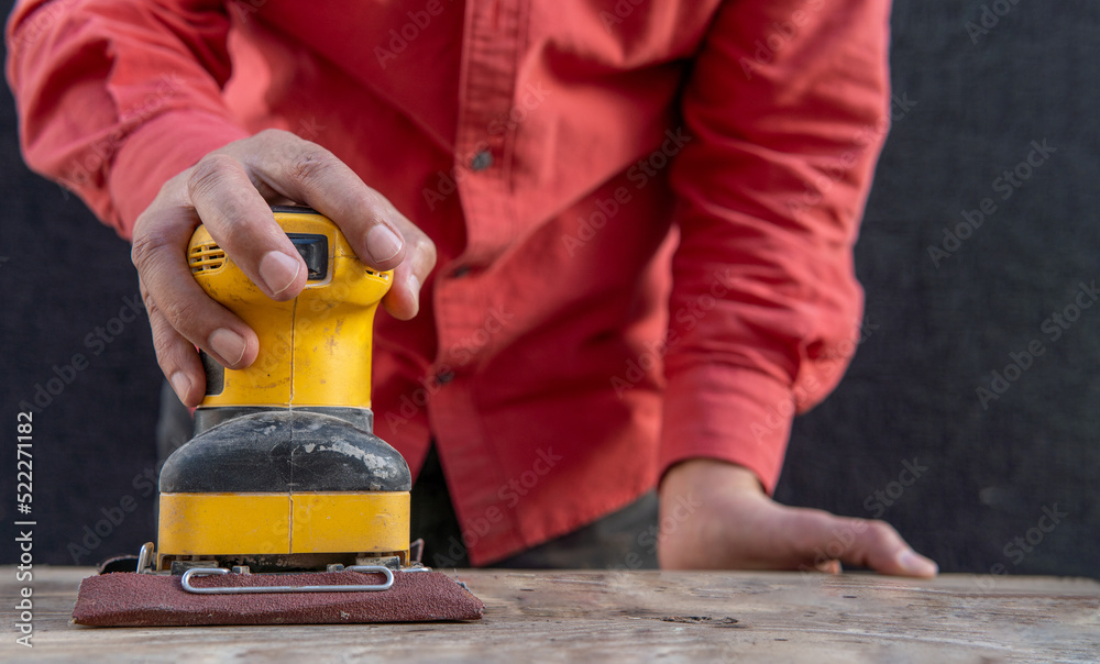 Unrecognizable man sanding wood with an electric sander