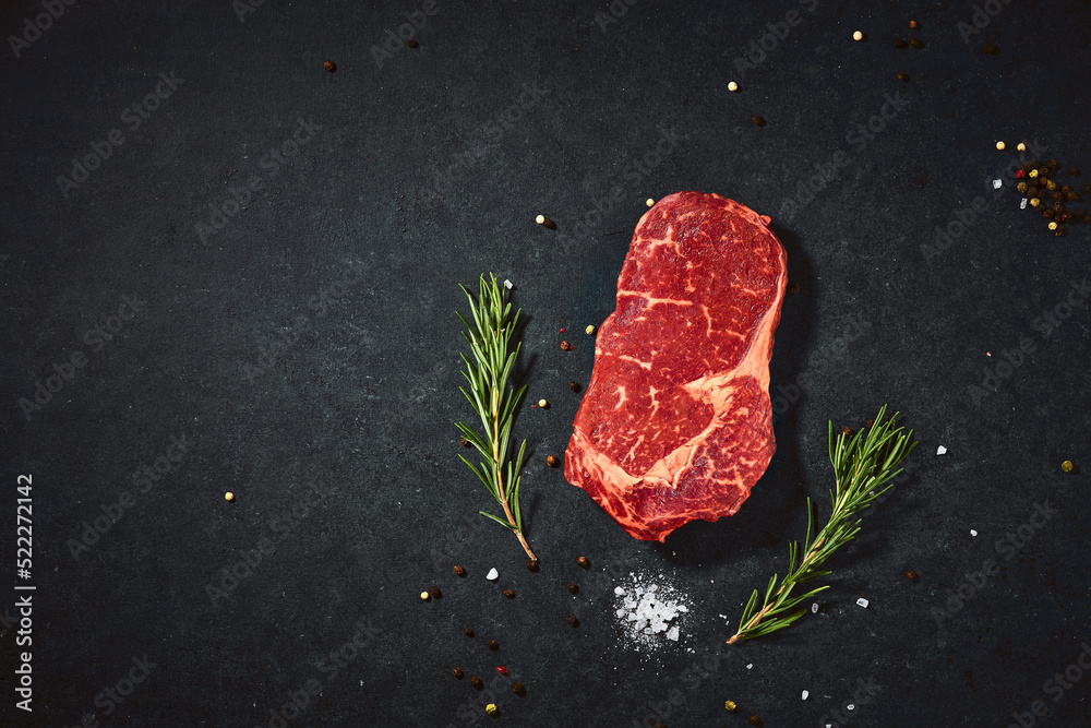 Top view fresh red raw meat with spice and salt. Beef steak on a dark table flat lay copy space background