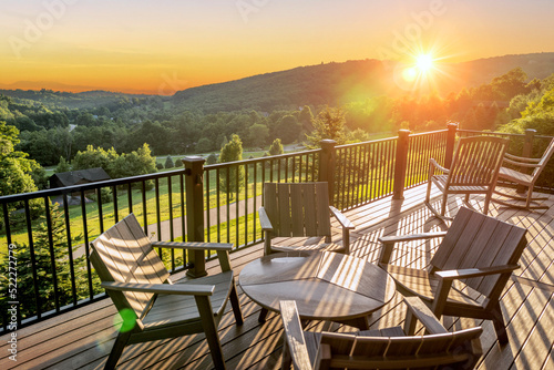 Beautiful dawn sunshine breaking over hills with wooden balcony