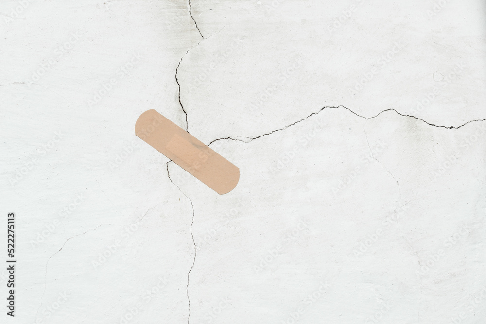 Bandage is stuck to a crack in the concrete wall. Old wall with cracks
