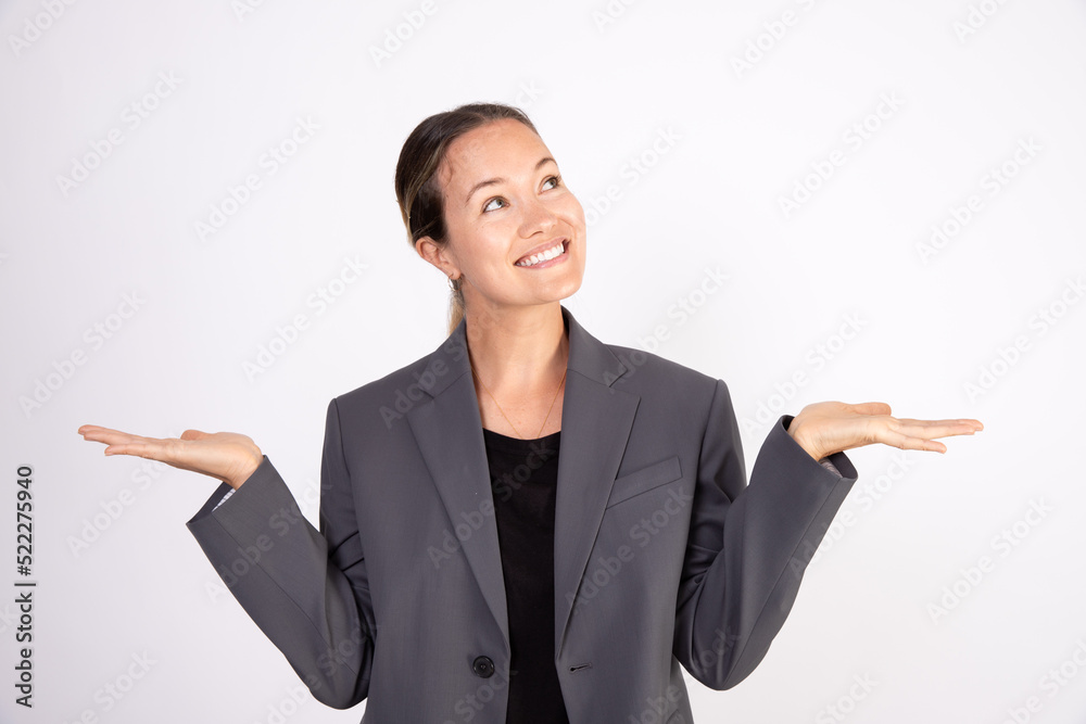 Portrait of happy businesswoman looking upwards in hope. Smiling Caucasian woman wearing gray suit coat and black blouse standing with hands outstretched. Business expectations concept Portrait of happy businesswoman looking upwards in hope. Smiling Caucasian woman wearing gray suit coat and black blouse standing with hands outstretched. Business expectations concept
