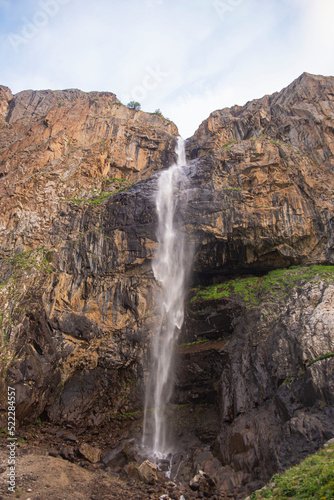 alpine waterfall in the mountains of kyrgyzstan flowing from melting glaciers close-up photo