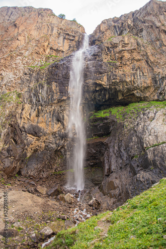 alpine waterfall in the mountains of kyrgyzstan flowing from melting glaciers close-up