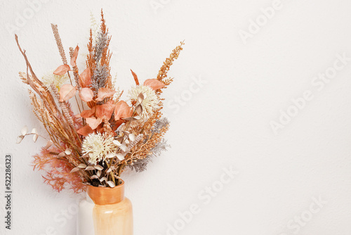 Composition of autumn flowers in ceramic vase as home decoration, white bakground