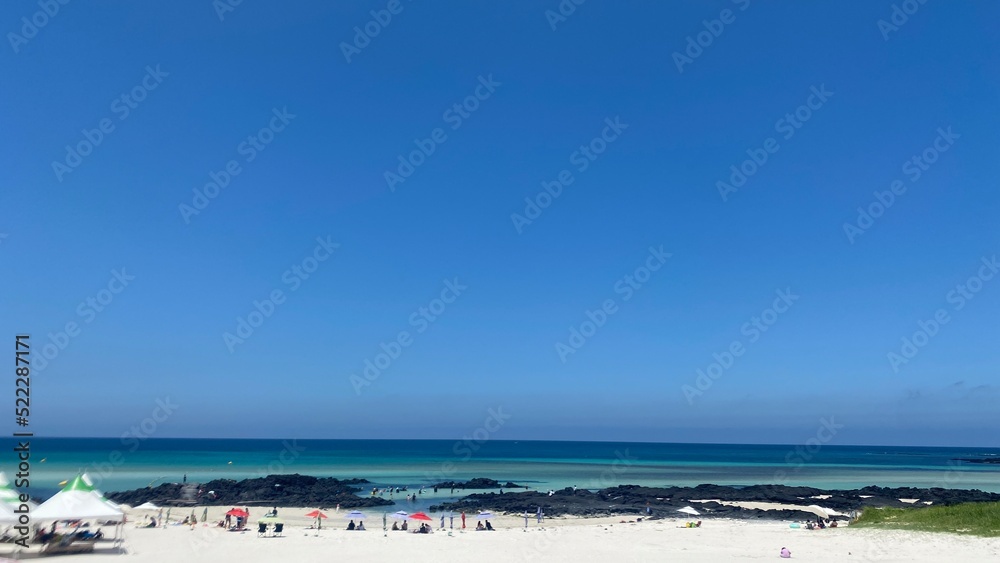 A picture of Jeju Island's blue sea and white sand beach.