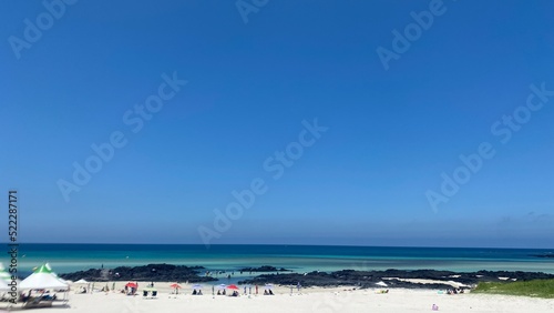 A picture of Jeju Island's blue sea and white sand beach.
