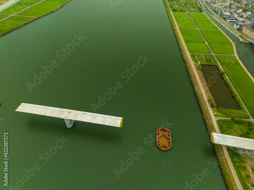 Aerial top-down view of bridge under construction and green riverside photo