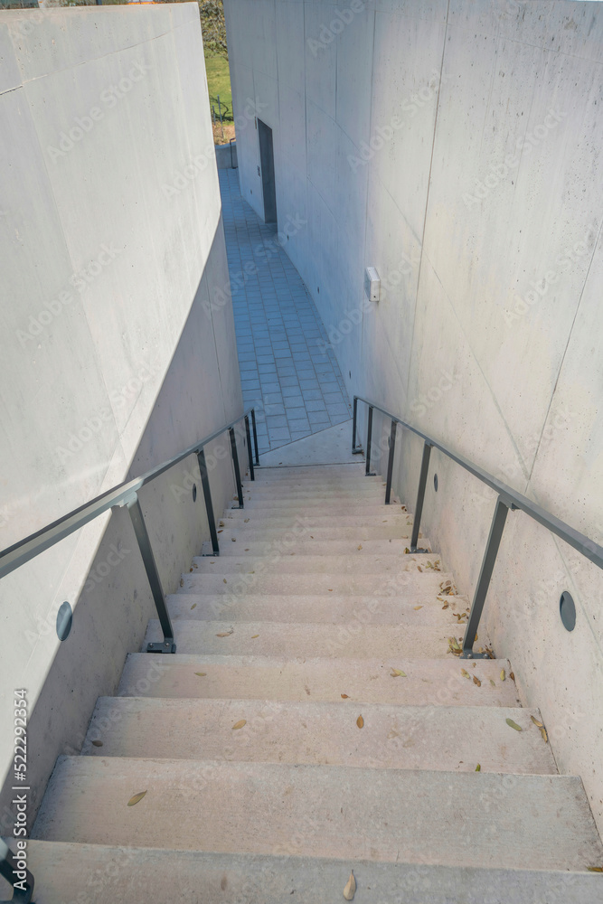 Staircase with metal handrails leading down to a stone tile pavement at Austin, Texas