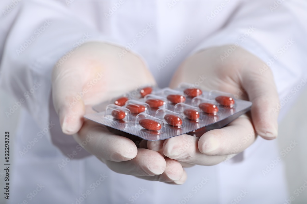 Doctor holding red pills, closeup. Anemia treatment Doctor holding red pills, closeup. Anemia treatment