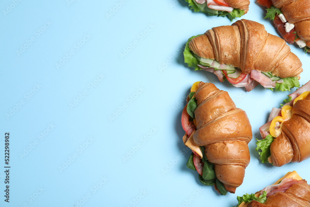 Croissant sandwiches on light blue background, flat lay. Space for text Croissant sandwiches on light blue background, flat lay. Space for text