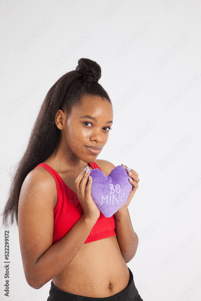 Pretty woman with a pleasing smile holding a stuffed heart Pretty woman with a pleasing smile holding a stuffed heart