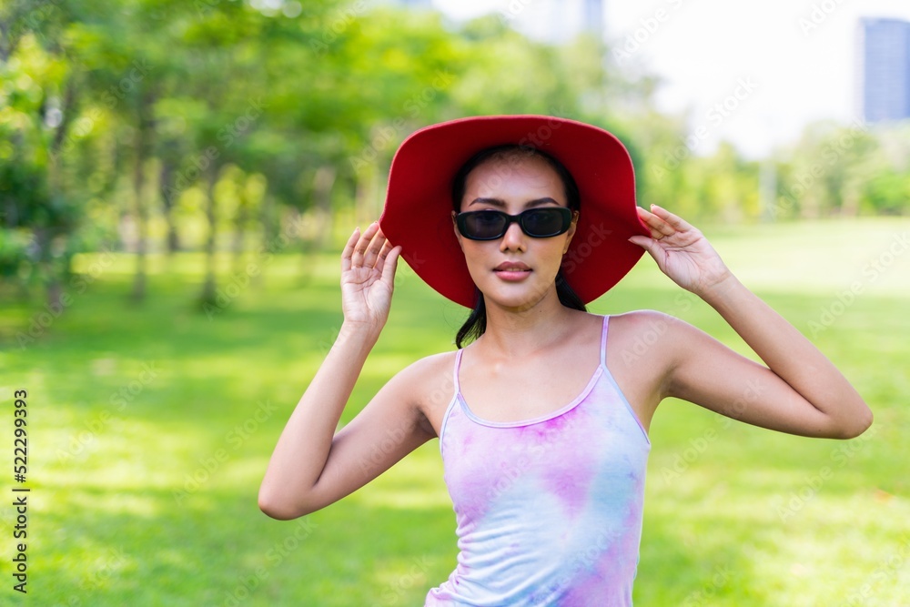Portrait photo of the beautiful moment of a young asian beautiful lady with red hat happily posing relaxingly at a garden park strolling Portrait photo of the beautiful moment of a young asian beautiful lady with red hat happily posing relaxingly at a garden park strolling