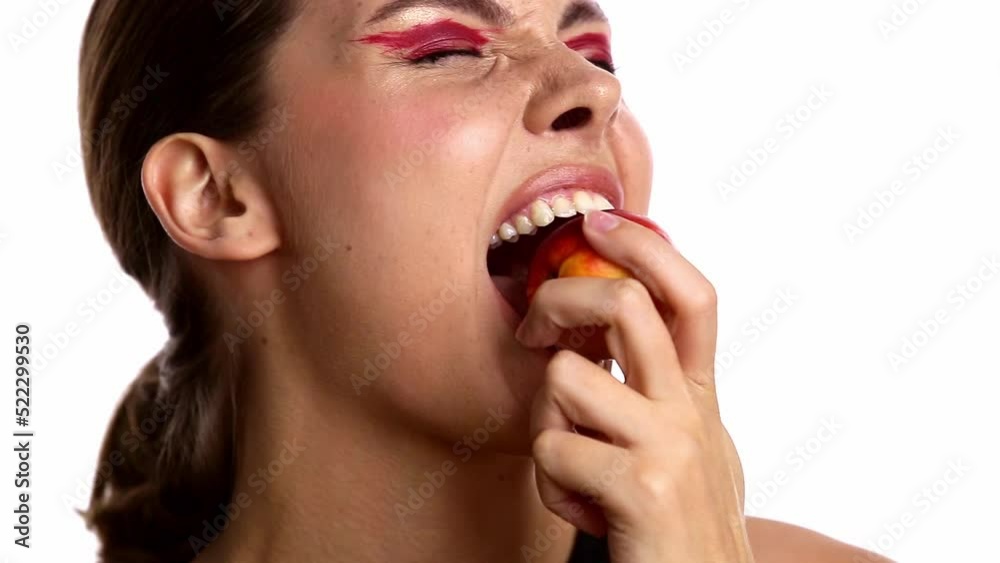 A young beautiful girl eats a peach. Bites a juicy peach. The concept of enjoyment A young beautiful girl eats a peach. Bites a juicy peach. The concept of enjoyment
