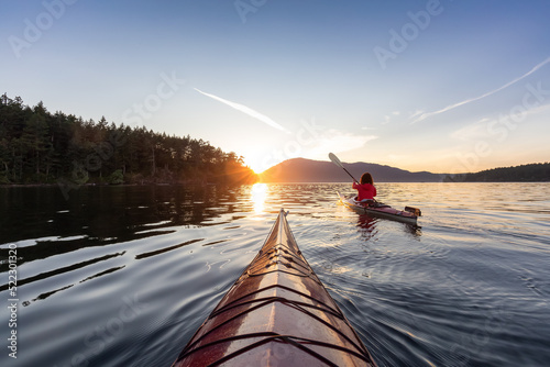 Photo Adventurous Woman on Sea Kayak paddling in the Pacific Ocean