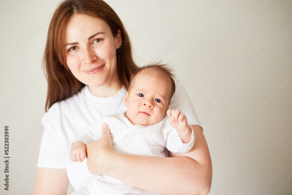 Mother holding her newborn baby. Home portrait of newborn baby and mother. Enjoying time together Mother holding her newborn baby. Home portrait of newborn baby and mother. Enjoying time together