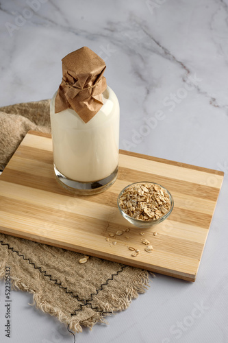
a bottle of milk and oatmeal on the table, next to a tea towel