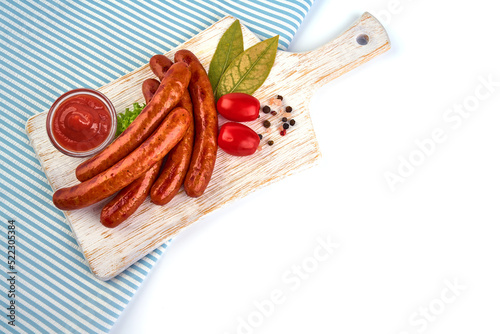 Grilled sausages with spices on rustic cutting board.