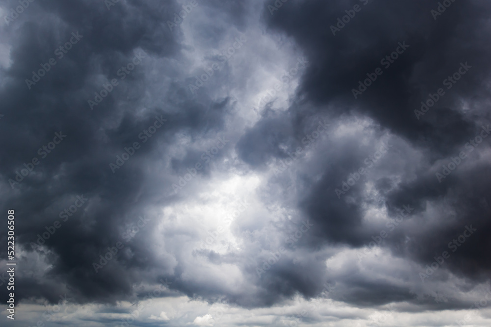 The dark sky with heavy clouds converging and a violent storm before the rain.Bad or moody weather sky and environment. carbon dioxide emissions, greenhouse effect, global warming, climate change.