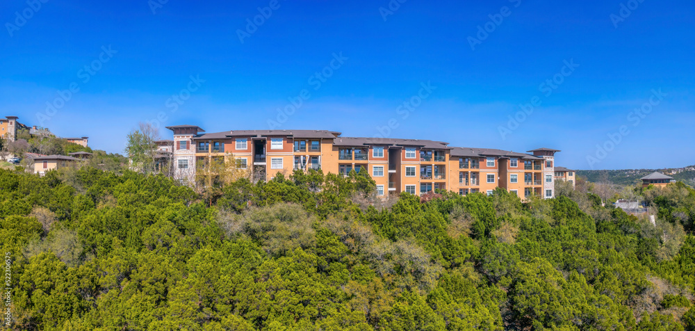Austin, Texas- Apartment buildings near the cliff of a mountain with trees on the slope