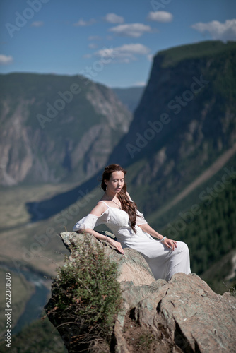 Bride in the mountains wedding image. A beautiful young woman in a wedding dress walks in the mountains.