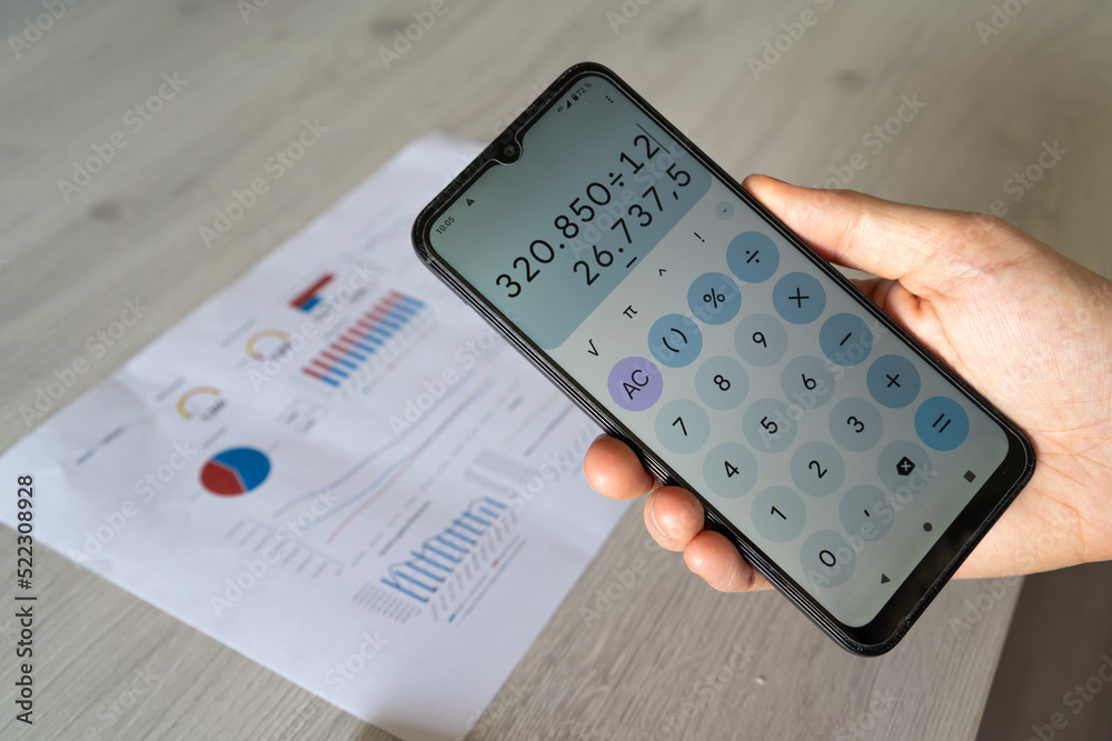 Man's hand holding a calculator to analyze and check the results and rates of the company Man's hand holding a calculator to analyze and check the results and rates of the company