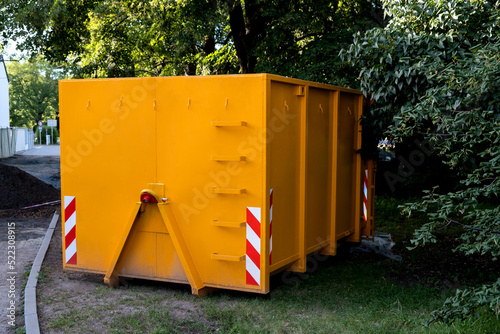 Yellow metal construction trash dumpsters container, house renovation. photo