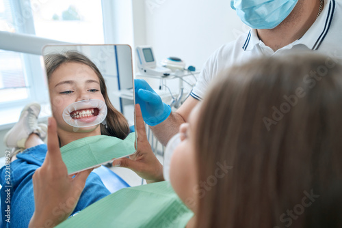 Teenage patient examining her teeth after dental procedure
