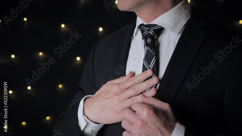 Close up view of man adjusts his tie.