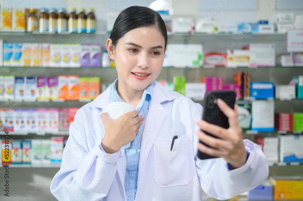 Female pharmacist counseling customer via video call in a modern pharmacy drugstore.