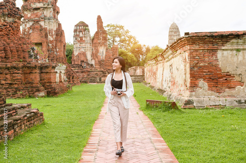 young beautiful woman traveling and taking photo at thai historical Park, Holidays and cultural tourism concept.