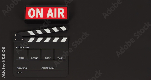 Black clapperboard or movie slate and on air on black background.