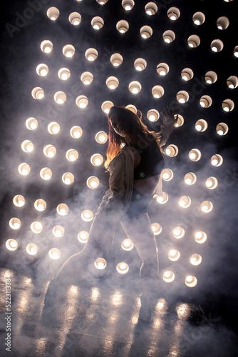 Sexy girl dance on front of spot light wall with smoke