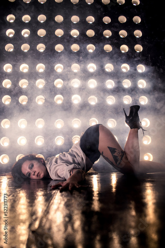 Sexy girl dance on front of spot light wall with smoke