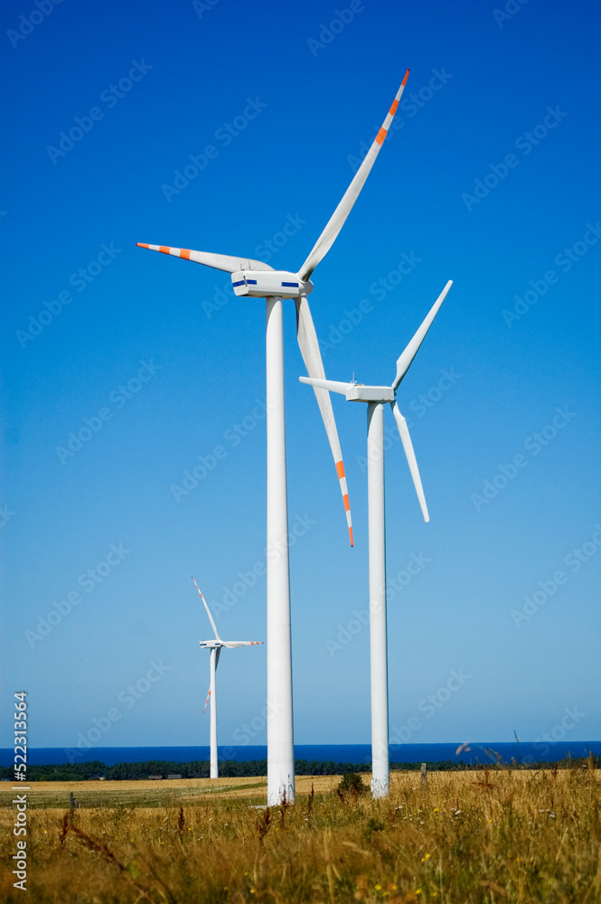 Fototapeta premium Windmill for electric power production against blue sky.