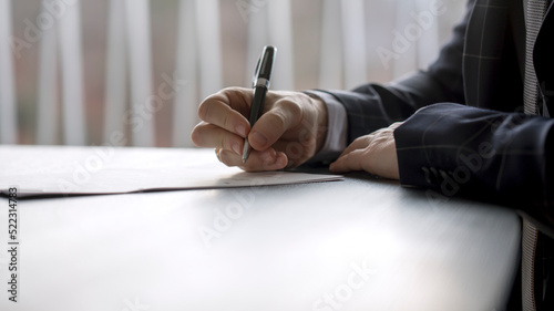 Schilderij op canvas Man signing a document in a law office or at a notary's table