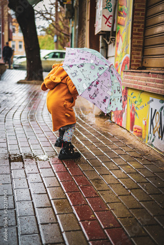 little girl with umbrella goes in the center from varna bulgaria  © Marius