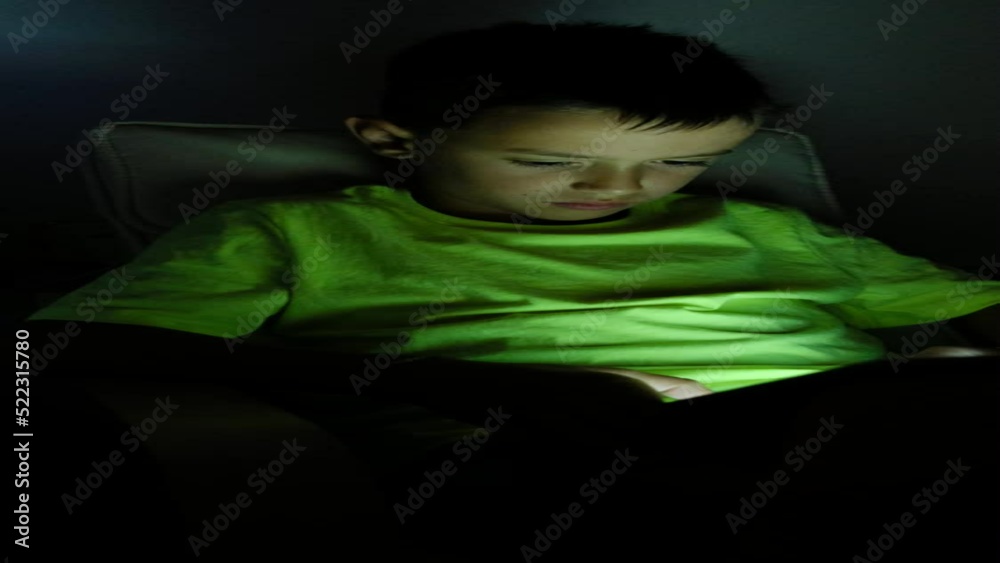 child plays video games in the dark. Vertical video child plays video games in the dark. Vertical video