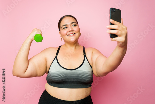 Plus size attractive active woman posting on social media her exercises